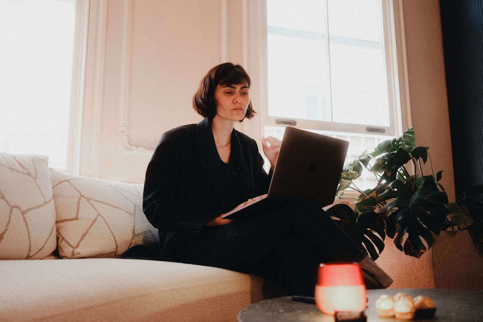 A woman looking at her laptop in a bright room