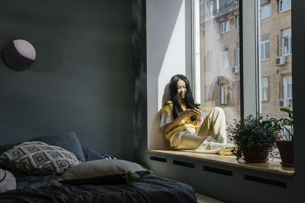 A woman reading on her phone at home