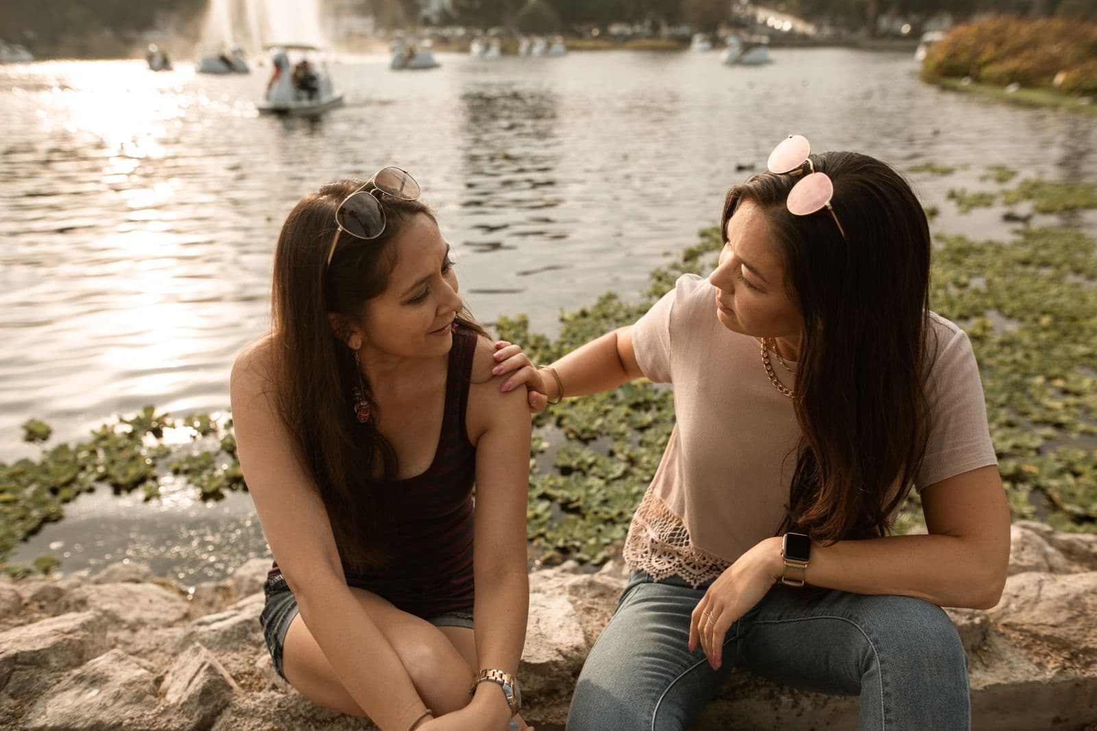 Two people talking beside a lake